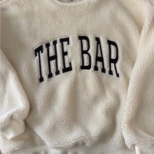 The Bar Cream Sherpa Top with Black Tag